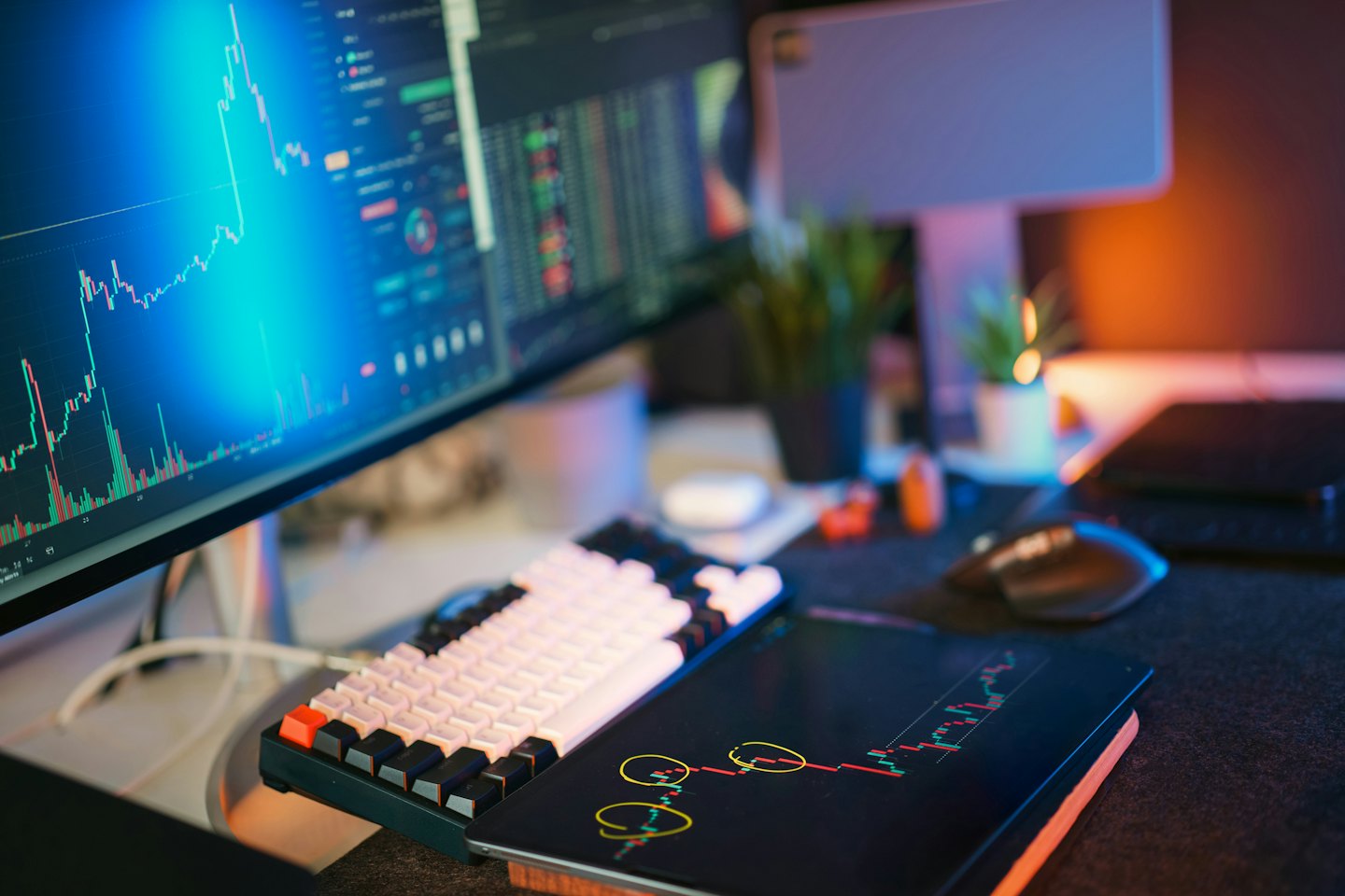Trading workstation with blue financial charts on monitor.