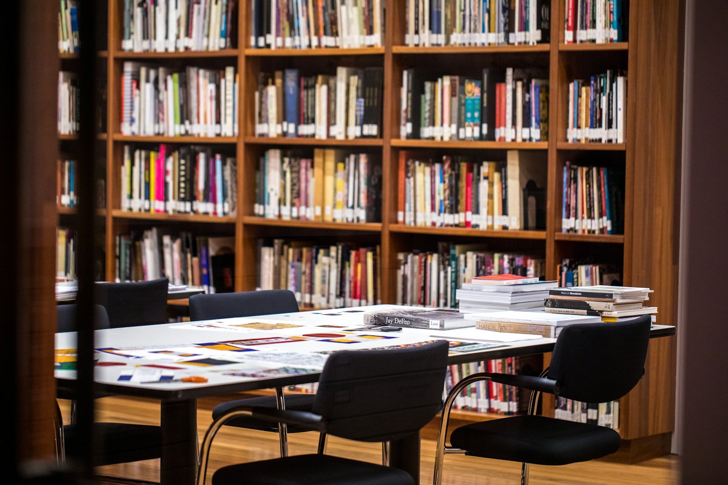 Books and papers rest on a table in a library.
